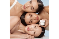 Three women with their heads on top of each other while holding Charlotte's Magic Beauty Water Cream.